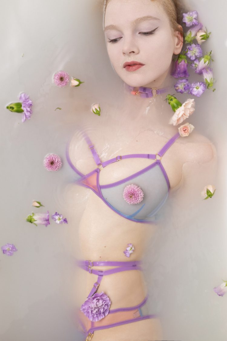 PAle skin model in milk bath and flowers wearing pastel lingerie