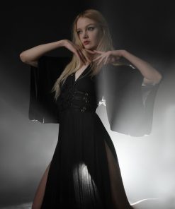 Dark photo of a blonde model in black satin kimono and bondage harness shot with strong backlight